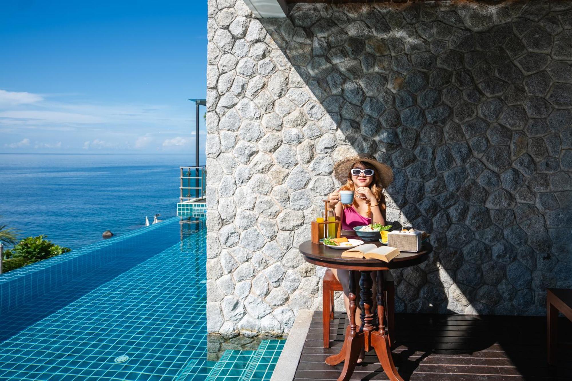 Zenmaya Oceanfront Phuket, Trademark Collection By Wyndham Patong Extérieur photo A woman enjoying a morning coffee at the poolside of the resort